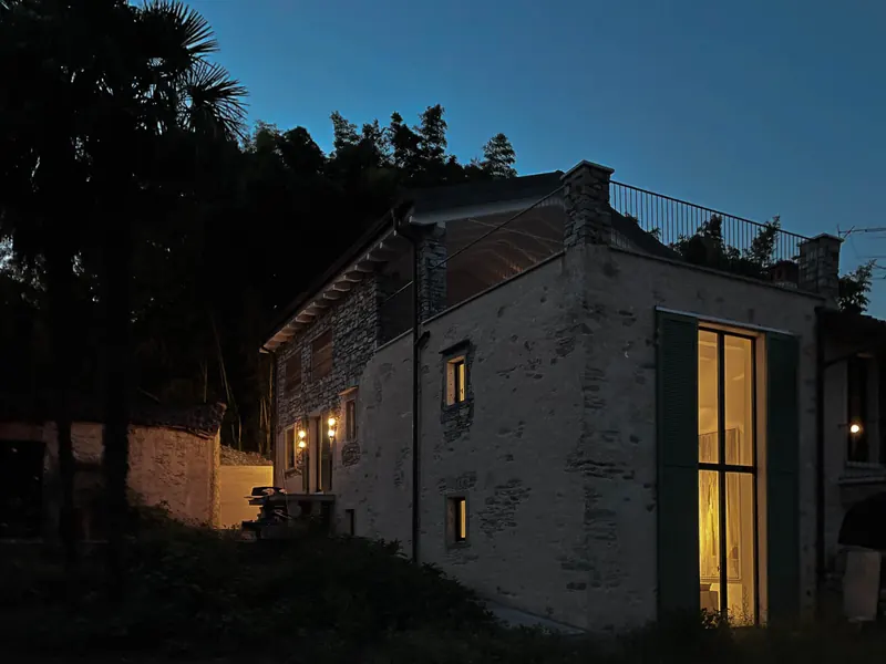 Casa Ludwig at dusk, restored rustico with illuminated tall windows