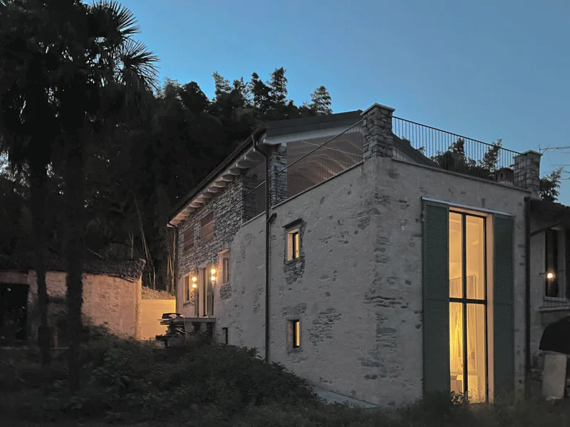 Casa Ludwig at dusk, restored rustico with illuminated tall windows